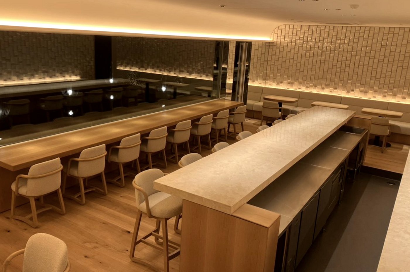 The cafe interior with a long stone counter, oak floor and hand-glazed tile wall